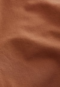 Tela marrón con una textura suave, que presenta un patrón de tejido sutil. El material parece duradero y flexible, adecuado para diversos usos.
