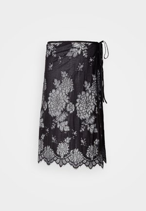 Black sheer wrap skirt with white floral lace patterns and scalloped hem, tied with a thin black string on the side.
