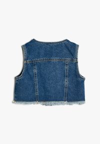 Jeansväst i medelblått med fransad nederkant, ärmlös design och synliga sömnadsdetaljer. Ingen stängning eller ytterligare dekorationer.