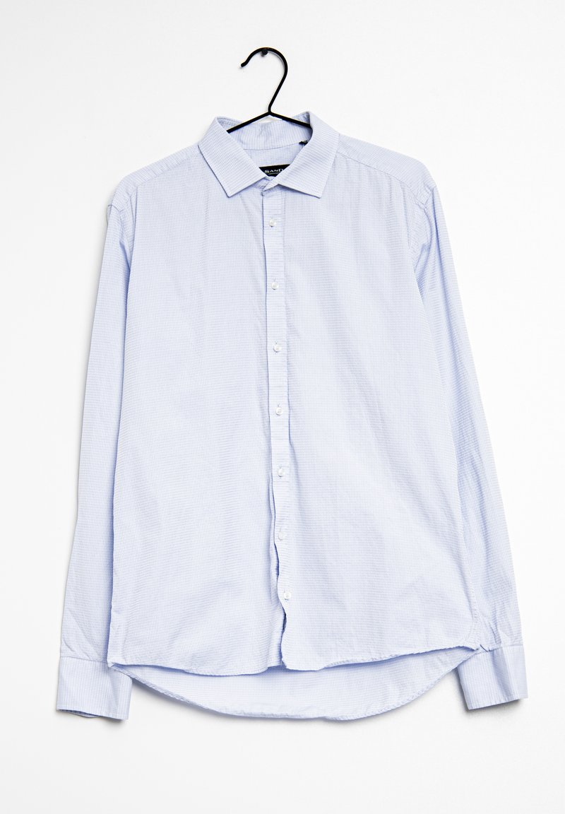 Ljusblå långärmad skjorta i bomull med knappslå framtill, krage och rundad nederkant med ett texturerat mönster genom hela skjortan.