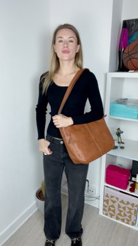 Geantă de umăr din piele maro cu o textură netedă, formă rectangulară și două cusături verticale; curea ajustabilă și design minimalist.