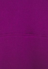 Lila sweatshirt-tyg med en mjuk textur, med en sömdetalj tvärs över midjan. Enhetlig färg och slät yta.