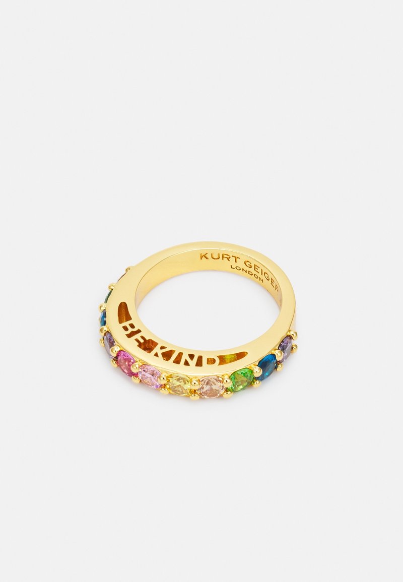 Bague en or avec des pierres précieuses multicolores et des lettres découpées formant "BE KIND,", gravée avec "Kurt Geiger London" à l’intérieur de l’anneau.
