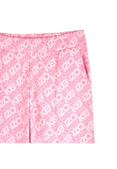 Pantalons plissés roses avec un motif logo blanc sur l'ensemble, fabriqués dans un tissu doux et dotés d'une taille élastique pour le confort et l'ajustement.