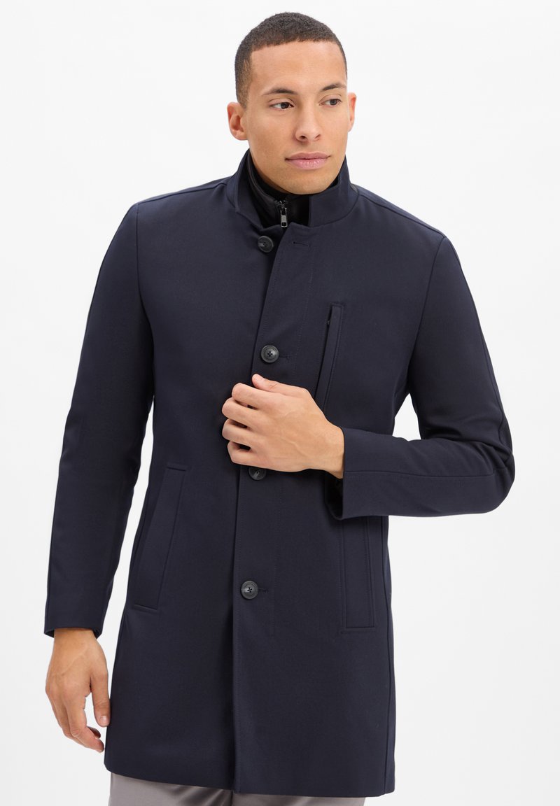 Marineblauer Mantel mit hohem Kragen, vorderem Knopfverschluss und Seitentaschen; glatte Textur und taillierte Passform mit einem eleganten Design.
