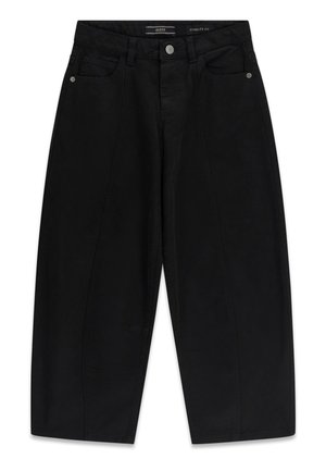 Jean noir oversized avec poches avant, bouton argenté et étiquette de la marque Guess à la ceinture.