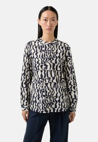 Lange mouw blouse van crèmekleurige stof met marineblauwe abstracte patronen, voorzien van een mandarin kraag en een ontspannen pasvorm.