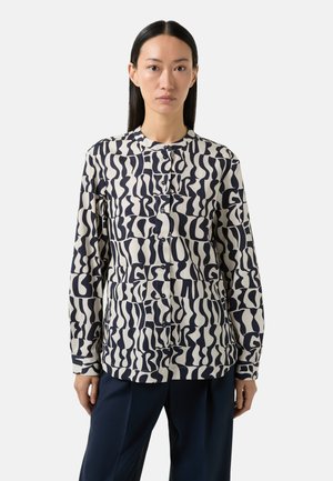 Long-sleeve button-up shirt in cream fabric with navy abstract patterns, featuring a mandarin collar and a relaxed fit.