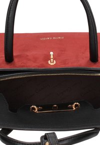 Borsa Pierre Cardin rossa e nera con chiusura dorata, manici in pelle nera e fodera interna con marchio, parzialmente aperta.