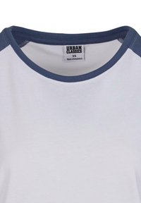 Fehér pamut póló sötétkék bordázott nyakkivágással és vállbetétekkel. A címke felirata: "URBAN CLASSICS XS", alatta pedig a "Bangladesben készült" felirat található.