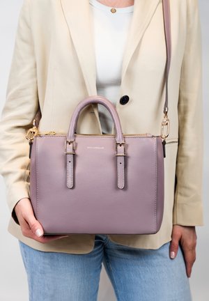 Sac à main en cuir violet clair avec des anses supérieures et une bandoulière amovible. Il est équipé de quincaillerie dorée et d'une fermeture éclair.