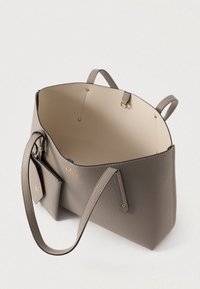 Sacola tote texturizada cinza com interior bege, grande abertura, alças duplas e um bolso exterior. Apresenta detalhes em tom dourado.