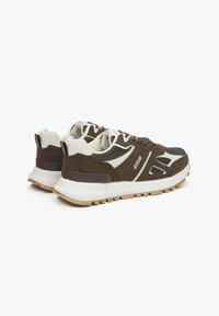 Brązowe i kremowe sneakersy z siateczkowym cholewką i gumową podeszwą, z warstwowym wzornictwem, teksturowanymi akcentami oraz wyraźnym logo marki.