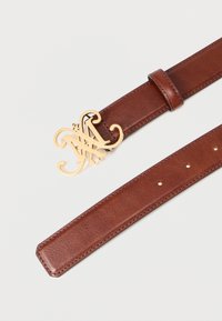 Bruine leren riem met een gouden siergesp, voorzien van een gladde textuur en meerdere gaten langs de band voor aanpassing.