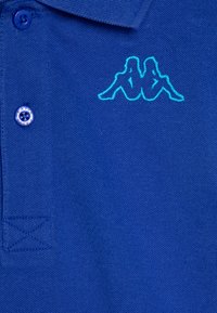 Modrá bavlněná polo košile s límečkem, která má jeden knoflík. Obsahuje vyšívané logo v tyrkysové barvě na hrudi a texturovanou látku.