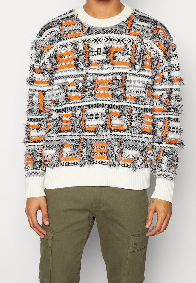 Flauschiger, gemusterter Pullover in Orange, Schwarz und Weiß; hat eine struppige Textur sowie einen gerippten Halsausschnitt und Saum.