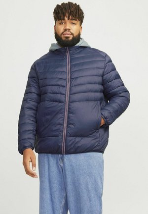 Marineblå pufferjakke med lynlåslukning og sidelommer, med en grå hætte og vandret quiltet design for isolering og varme.