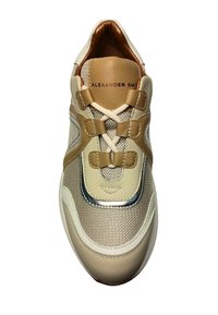 Sneaker beige e sabbia realizzato in materiali mesh e pelle, con cuciture evidenti, fiocchi decorativi sui lacci e un accento metallico vicino alla punta.