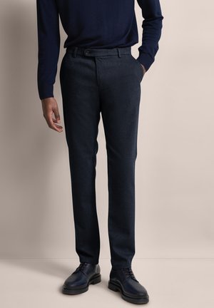 Pantaloni scuri in navy su misura in un tessuto texturizzato con gamba dritta, dotati di tasche anteriori e chiusura con bottone a contrasto.