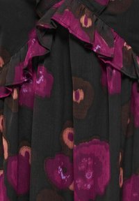 Tissu foncé avec de grands motifs floraux violets et marron, avec des volants superposés le long des bords.