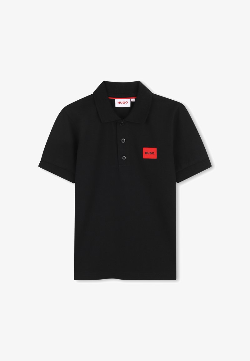 Μαύρο πόλο μπλουζάκι κατασκευασμένο από βαμβάκι, με γιακά, τρία κουμπιά, κοντά μανίκια και ένα κόκκινο ορθογώνιο λογότυπο στο στήθος.