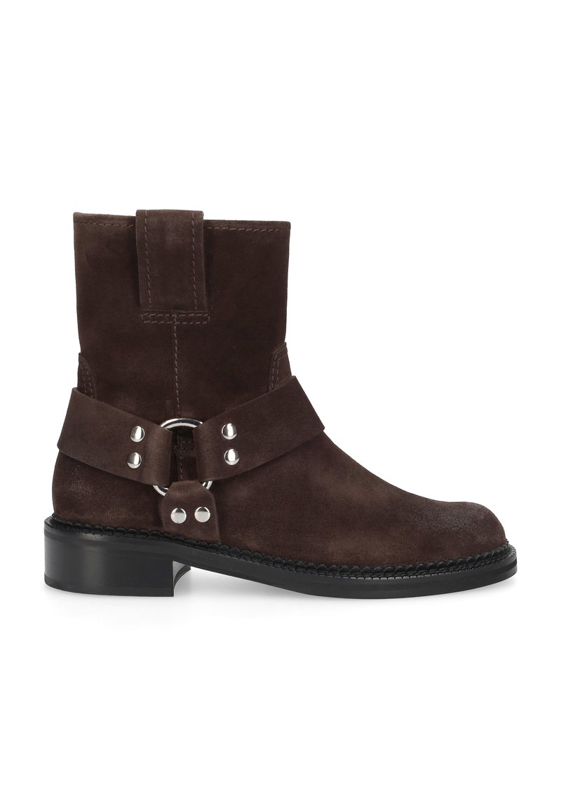 Bottine en daim marron avec un bout arrondi. Dotée d'une sangle et d'une boucle avec des accessoires en argent. Semelle en caoutchouc noire avec des accents cousus.