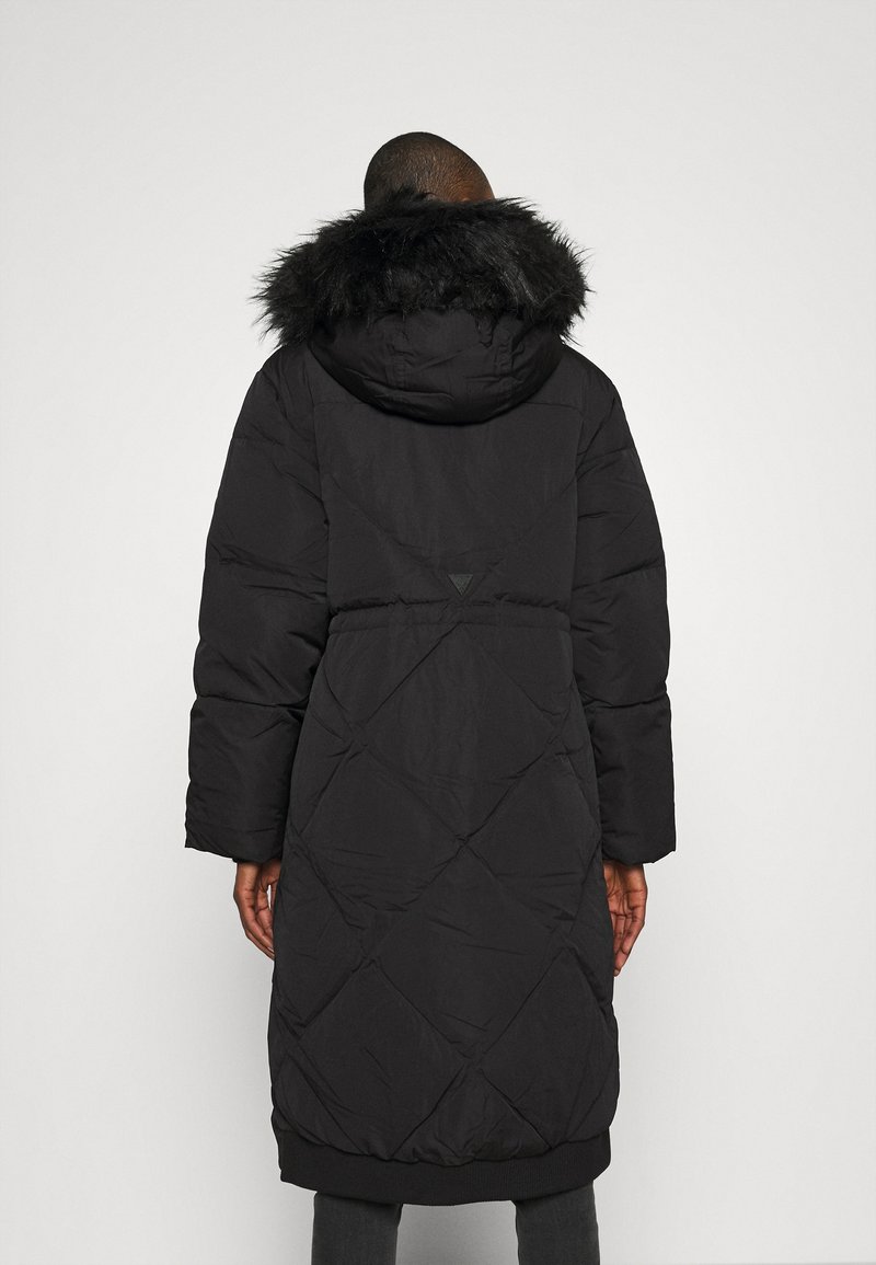 Černý plněný kabát s velkou kapucí lemovanou kožešinou, prošívaný design, dlouhé rukávy a žebrované manžety. Obsahuje stahovací pas a logo na zadní straně.