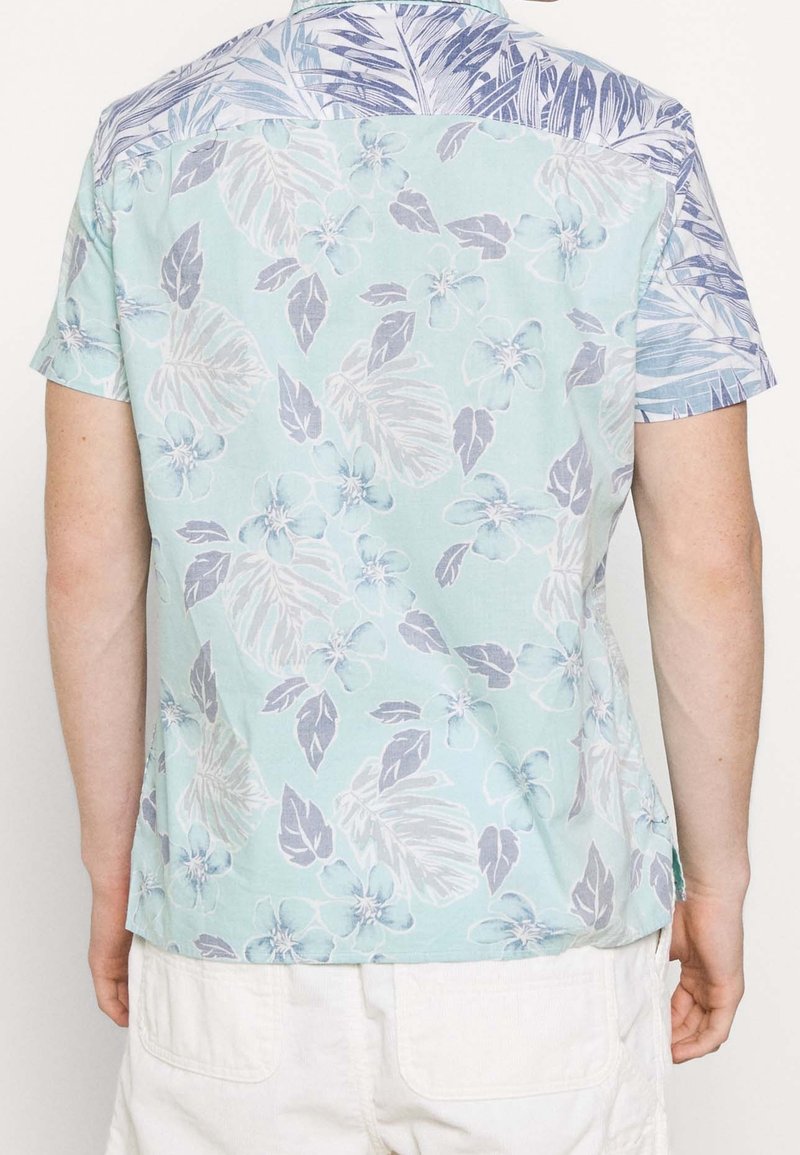 Koszula z krótkim rękawem w jasnym zielonym kolorze z różowymi i niebieskimi wzorami kwiatowymi. Posiada niebieski, wzorzysty karczek. Wykonana z lekkiego materiału.