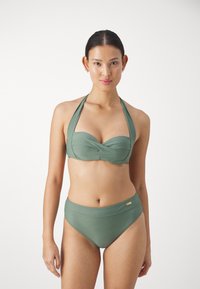 Grønn bikini-sett med en vridd bikini topp med stropper og høy midje-bunn. Glatt stoff med subtil glans, minimal maskinvare-detalj.