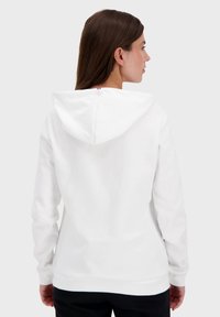 Felpa bianca con cappuccio sul retro, texture morbida e maniche lunghe. Presenta un piccolo accento rosso, bianco e blu sul collo.