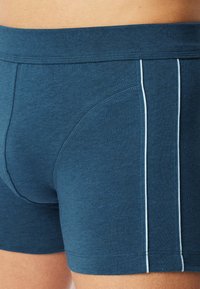 Herrboxershorts i mörkblå bomullsblandning. Har en mjuk midja och kontrasterande ljusblå sidostreck. Slät textur, figurnära passform.