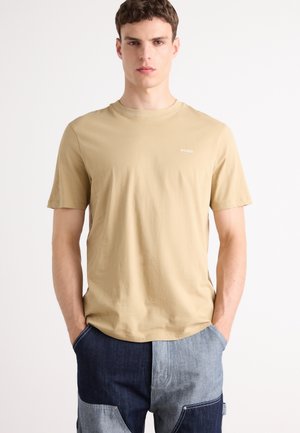 Beige kortærmet t-shirt lavet af blødt materiale, med rund halsudskæring og et lille hvidt "Hugo" logo på brystet.