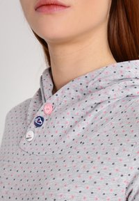 Grå bomulls hoodie med rosa och marinblå prickar, med en lätt krage, tre knappar i olika färger, och en mjuk textur.