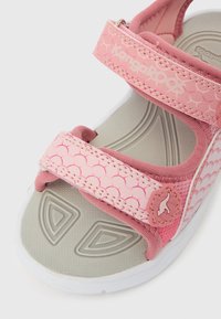 Ροζ παιδικό σανδάλι με δύο ρυθμιζόμενους ιμάντες, γκρι υφ ασμάτινη πάτημα και λογότυπο KangaROOS στον πάνω ιμάντα και στο πλάι.