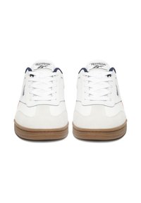 Baltos sportinės avalynės su zomšos akcentais, suvarstomu dizainu, gumine padu ir tamsiai mėlynais detalėmis ant liežuvėlio ir logotipo. Viršus tekstūruotas su minimaliais raštais.