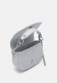 Lichtgrijze suède schoudertas met zilverkleurig beslag, ronde vorm, magnetische sluiting en een korte leren handgreep met kettingaccenten.