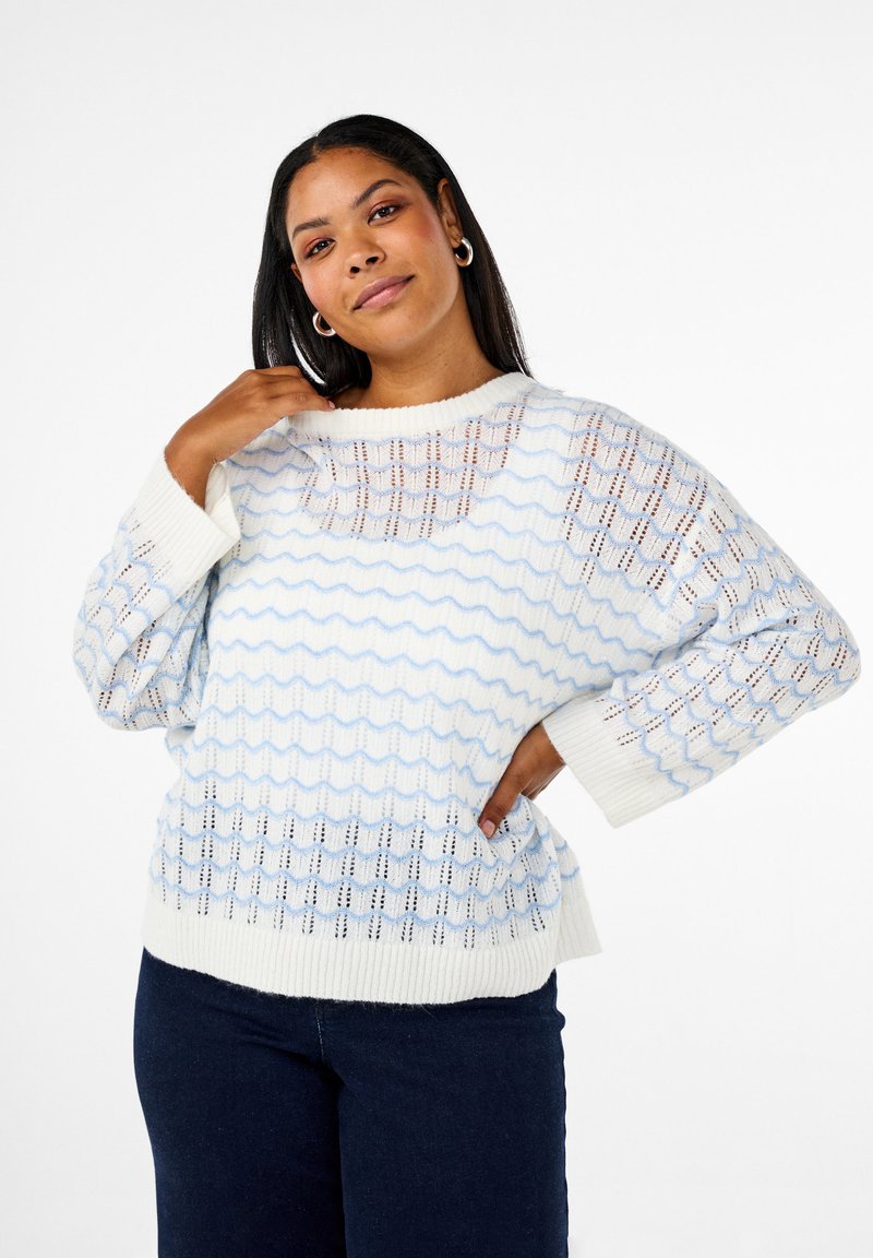 Pull en tricot bleu clair et blanc avec des motifs en vagues et une coupe ample. Comprend des manches longues et une encolure dégagée. Tissage aéré texturé.