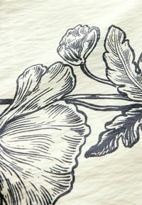 Illustration florale à l'encre noire avec des pétales et des feuilles détaillés sur un fond en tissu texturé blanc cassé.