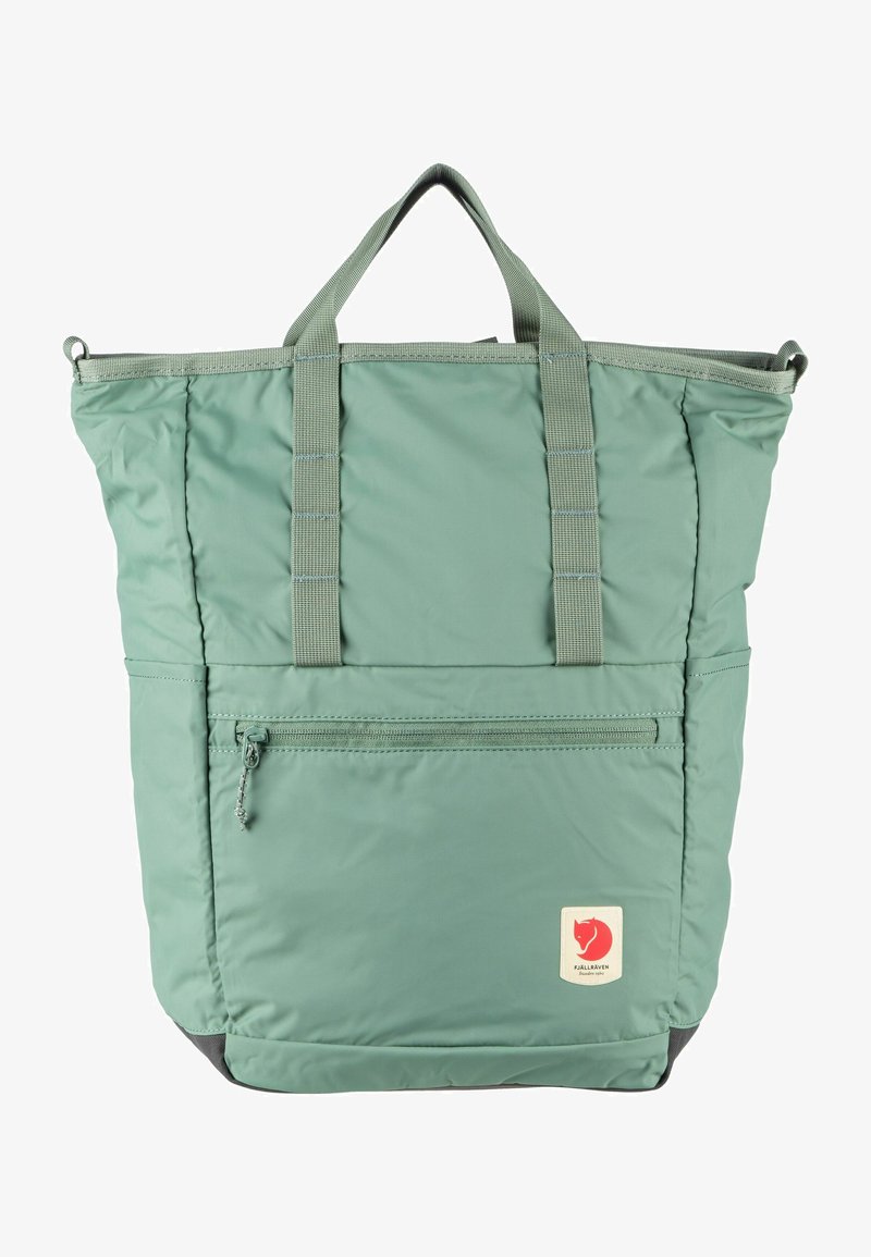 Lichtgroene nylon draagtas met dubbele handgrepen, ritszak aan de voorkant, gevoerd lichaam en een logo patch rechtsonder.