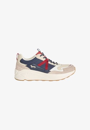 Marineblå, beige og hvid sneaker med røde detaljer, tyk sål, side hundelogo og snørelukning på hvid baggrund.