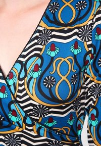 Multicolored wrap top featuring a blue and black striped pattern, floral motifs in turquoise and red, and a smooth fabric texture.