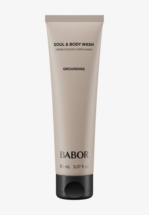 Tube de gel douche Babor Soul & Body, beige avec texte noir. Capuchon noir à vis. Contient 150 mL. Présente une étiquette "Grounding". Fini lisse et mat.