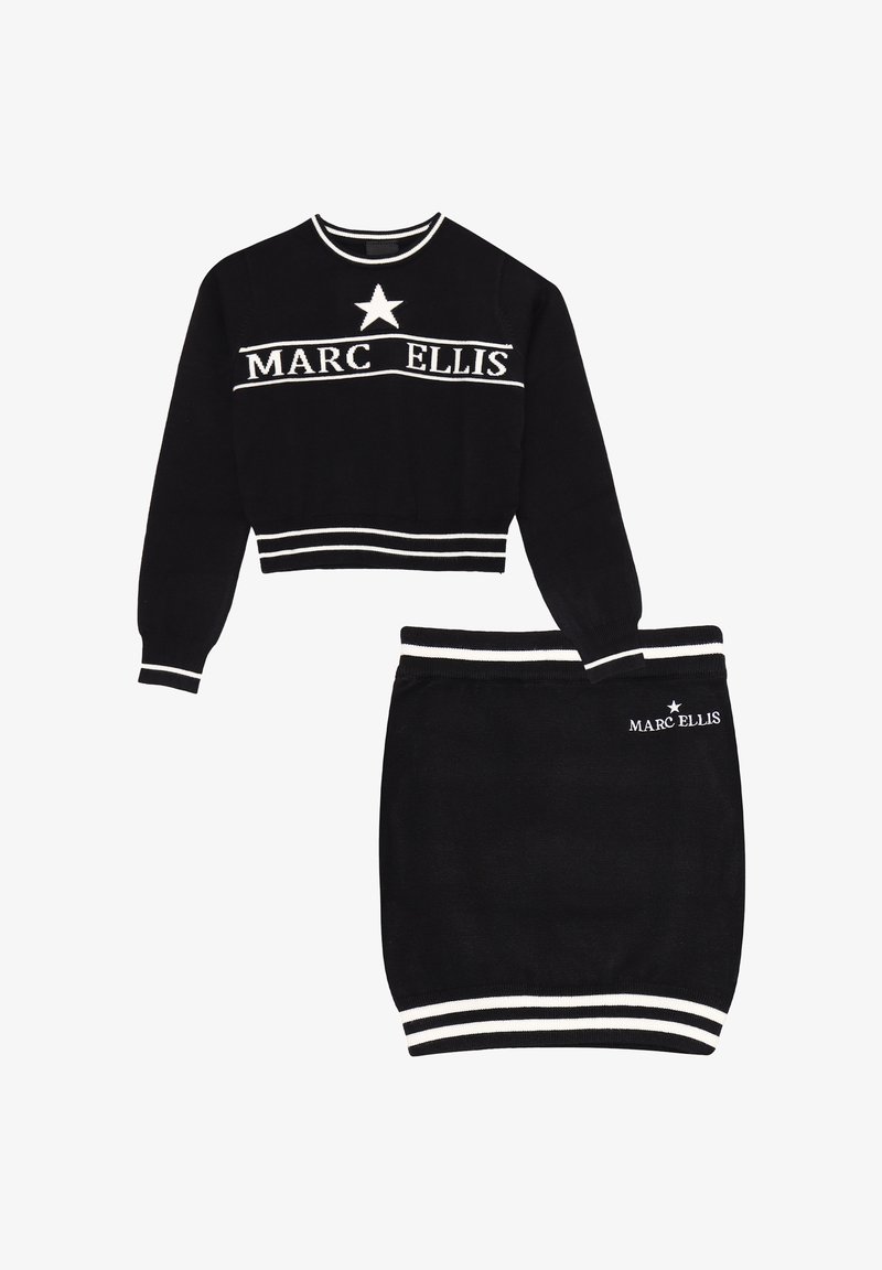 Set composto da maglione corto nero e gonna a tubino con strisce bianche e testo "MARC ELLIS". Il maglione ha maniche lunghe e un accento a stella.