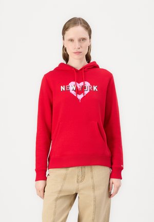 Felpa rossa con tasca frontale, decorata con un design a forma di cuore rosa e la scritta "NEW YORK" in bianco. Realizzata in un tessuto morbido e caldo.