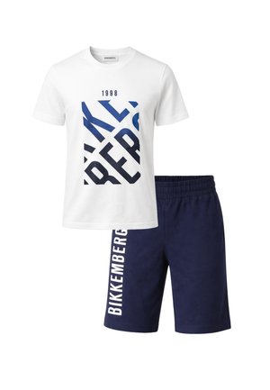 T-shirt bianca a maniche corte con scritta astratta blu "Bikkembergs 1998" abbinata a pantaloncini elasticizzati blu navy con "Bikkembergs" sulla gamba.