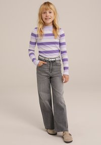 Hosszú ujjú ing világos lila és fehér csíkokkal; párosítva magas derekú, fakó szürke, bő szárú farmernadrággal és bézs klumpával.