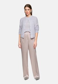 Light lavender knitted cardigan with diamond pattern, paired with beige wide-leg pants featuring a smooth, silky texture.