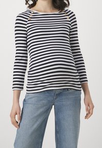 Marinblå och vit randig långärmad tröja med rund halsringning, guldknappdetaljer vid axlarna, figurnära vid bysten och avslappnad form mot midjan.