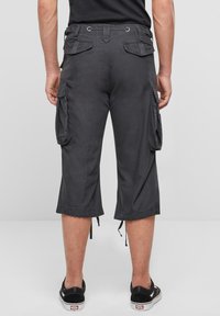 Harmaat cargo-shortsit, joissa sivutaskut, polven mittaiset, väljät, säädettävillä nyöreillä helmassa ja vahvistetut saumat.