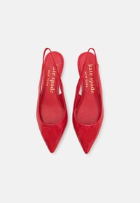 Piros lakkbőr, slingback fazonú cipők hegyes orral, a frontrészén szív alakú varrott mintával és márkás talppal.